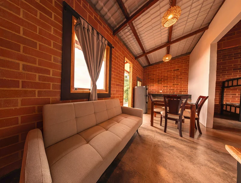 Sala de la cabaña con sofá y comedor
