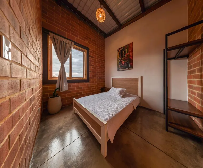 Habitación de la cabaña para 5 personas con cama y ventana — Finca Hotel Los Balcones, Filandia