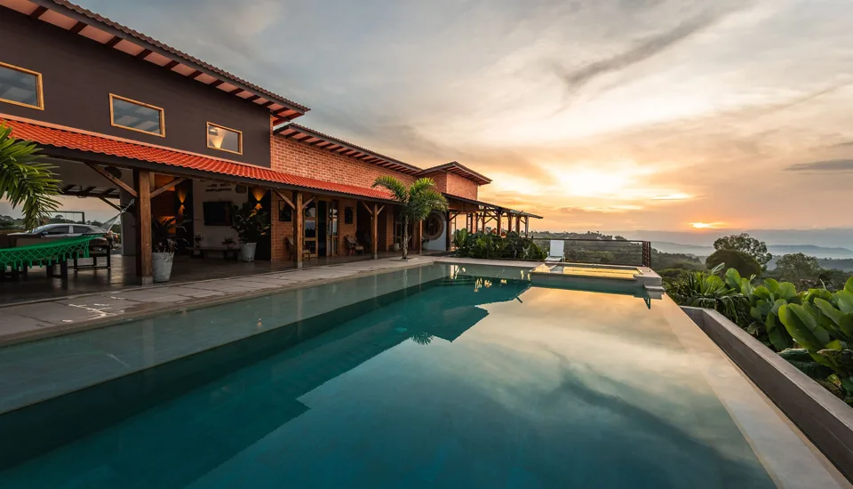 Piscina y fachada de Los Balcones con las montañas al atardecer