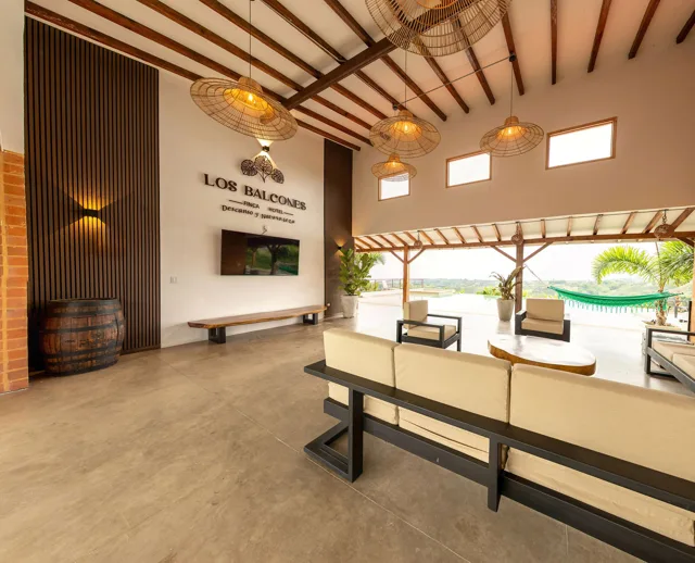 Sala abierta de la finca con mobiliario y techo de madera